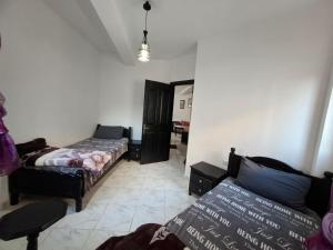 a room with two beds and a couch in it at RESIDENCE AL Hoceima 2 Minutes de prés de PLAGE CALABONITA in Al Hoceïma