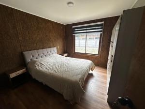 a bedroom with a large bed and a window at Cabañas y hospedaje kalú in Nueva Imperial
