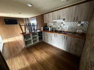 a kitchen with wooden cabinets and a wooden floor at Cabañas y hospedaje kalú in Nueva Imperial