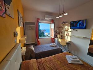 a small room with two beds and a window at ele&gio accomodation - Sea View in Tropea