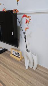a flower in a white vase sitting on a table at Sleep Owl Surat Thani in Surat Thani