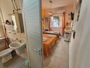a small bathroom with a bed and a sink at ele&gio accomodation - Sea View in Tropea +270 photos