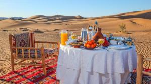 a table with food and drinks in the desert at Best Classic Sahara Experiences in Merzouga
