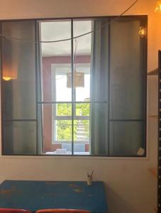 a window with a blue table in front of it at Petit nid calme à 2 pas de Paris in Ivry-sur-Seine