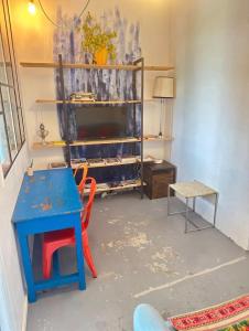 a room with a blue table and a chair and a desk at Petit nid calme à 2 pas de Paris in Ivry-sur-Seine +7 photos