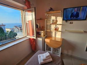 a room with a window and a tv and a table at ele&gio accomodation - Sea View in Tropea