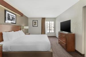 a hotel room with a bed and a flat screen tv at Best Western Plus Boomtown Casino Hotel in Verdi