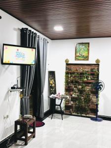 a living room with a brick fireplace and a television at Regnum Villa Anuradhapura in Anuradhapura