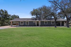 a house with a green lawn in front of it at 2 Creeks in Wimberley