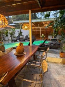 a dining room with a table and a swimming pool at Sanctuary Puerto Viejo in Cocles