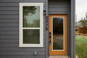 an orange door on a gray house at A Stunning Escape in Canyon Lake