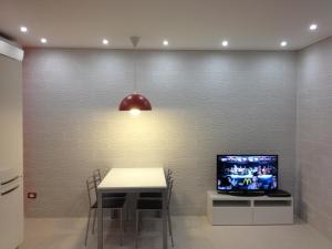 a dining room with a table and a tv on a wall at Villa Bebe' in Vico Equense +68 photos