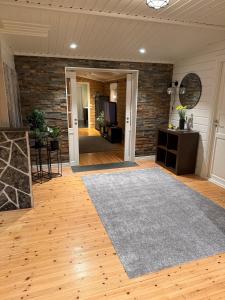 a living room with a rug and a brick wall at Koselig hytte in Skillemo