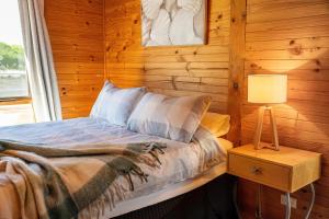 a bedroom with a bed with a lamp and a window at The Dunes Hideaway in Dolphin Sands +15 photos