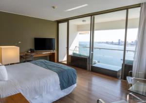 a hotel room with a bed and a large window at Terrado Suites Iquique in Iquique