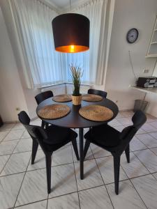 a dining room table with chairs and a lamp at Ferienhaus Wattgeflüster Neßmersiel in Neßmersiel