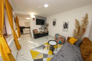 a living room with a couch and a tv at Hedonist Spa Jacuzzi Centar Free private parking in Sarajevo