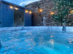 a large swimming pool with blue water in a house at The Manor House in Peel