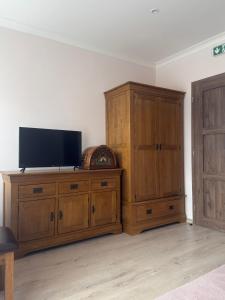 a flat screen tv on top of a wooden cabinet at Hrochoťský mlyn in Hrochoť