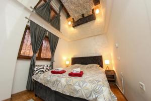 a bedroom with a large bed with red towels on it at Hedonist Spa Jacuzzi Centar Free private parking in Sarajevo +123 photos