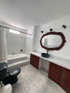 a bathroom with a tub and a sink and a mirror at La Arteza Pacasmayo in Pacasmayo