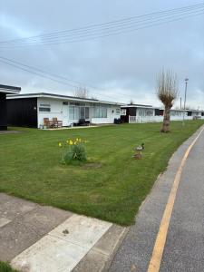 a house with two ducks in the grass near a street at Chalet 65 in Chapel Saint Leonards