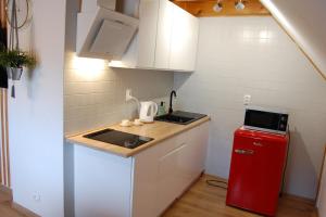 a small kitchen with a sink and a red refrigerator at Spokojny Potok Sopot - AFRA GROUP in Sopot