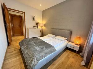 a bedroom with a bed and a lamp in it at Spokojny Potok Sopot - AFRA GROUP in Sopot