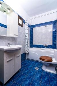 a bathroom with a toilet and a tub and a sink at Menir Apartments in Prinos +70 photos