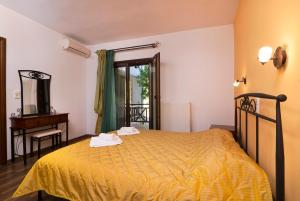a bedroom with a bed with a yellow bedspread at Menir Apartments in Prinos