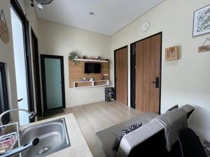 a bathroom with a sink and a living room at Menata Villa Harmoni in Pakem