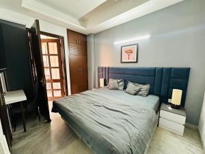 a bedroom with a large bed with a blue headboard at Remix stays in Gurgaon