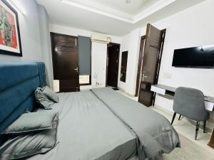 a bedroom with a bed and a television and a chair at Remix stays in Gurgaon