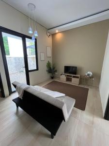 a living room with a couch and a tv at Menata Villa Harmoni in Pakem