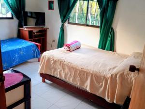 a bedroom with a bed and a desk and a window at Cabaña Villa Gabi in San Antero