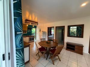 a kitchen and dining room with a table and chairs at Plage privée - Vahine Ori Lodge in Raiatea