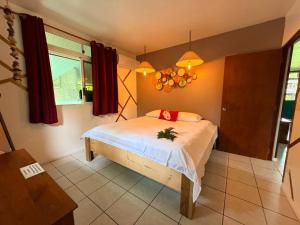 a bedroom with a bed and a window at Plage privée - Vahine Ori Lodge in Raiatea