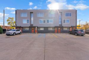 a building with two cars parked in a parking lot at Modern Birmingham Retreat in Birmingham
