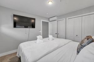 a white bedroom with a large white bed with two pillows at Modern Birmingham Retreat in Birmingham