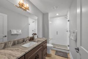 a bathroom with a sink and a toilet and a mirror at Modern Birmingham Retreat in Birmingham +18 photos