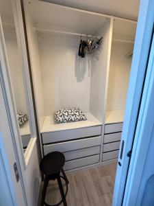 a closet with white cabinets and a stool in it at Vista Lago in Basiglio