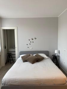 a white bedroom with a bed with four pillows at Vista Lago in Basiglio