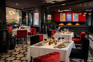 a restaurant with white tables and chairs and a fireplace at BAB HOTEL Marrakech, Boutique Hôtel & SPA in Marrakesh