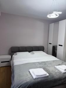 a bedroom with a large bed with two towels on it at Trea Apartment in Tirana