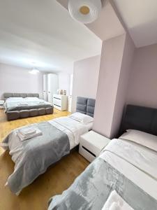 two beds in a room with white walls at Trea Apartment in Tirana