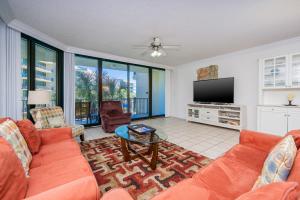 a living room with orange furniture and a flat screen tv at Phoenix on the Bay 1213 in Orange Beach +39 photos