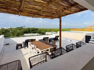 an outdoor patio with a wooden table and chairs at Casa Daniela in Puerto Morelos