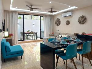 a living room with a table and blue chairs at Casa Daniela in Puerto Morelos