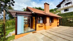 a small house with a large glass door at Chalés Leopoldo em Monte Verde in Monte Verde