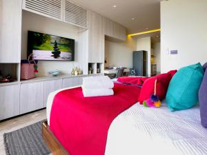 a bedroom with a large bed with a red blanket at Casa La Aurora - Beachfront Studio and Rooftop Infinity Pool in Puerto Morelos